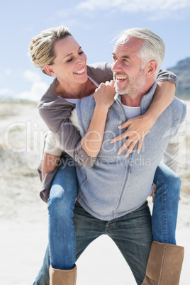 Laughing couple smiling at each other on the beach