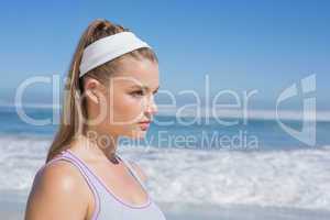 Sporty serious blonde standing on the beach