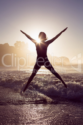 Happy blonde in the sea leaping in bikini