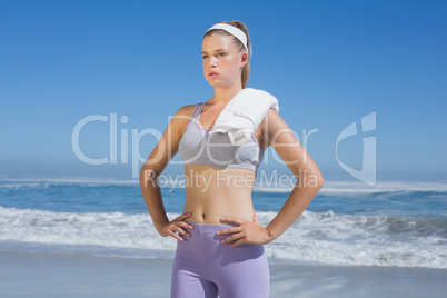 Sporty blonde standing on the beach with towel