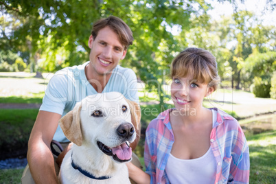 Cute couple with their labrador dog in the park