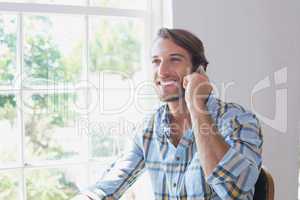 Handsome man sitting at table talking on phone
