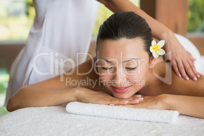 Brunette enjoying a peaceful massage with eyes closed