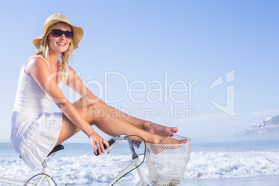 Gorgeous happy blonde on a bike ride at the beach