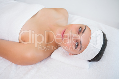 Peaceful smiing brunette lying on massage table