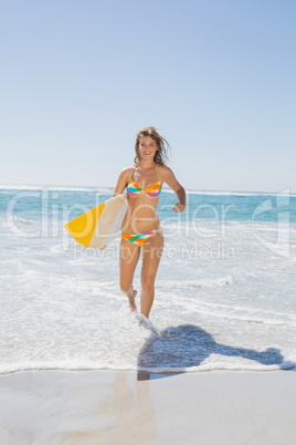Beautiful surfer girl walking from the sea with her surfboard