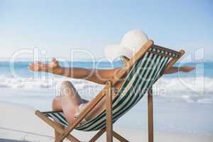 Woman relaxing in deck chair with arms outstretched