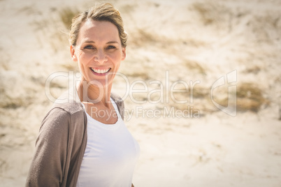 Smiling blonde woman standing on the beach