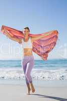 Sporty blonde standing on the beach with a scarf