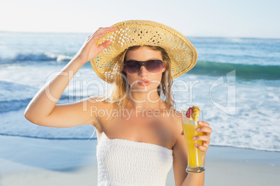 Beautiful blonde in white sundress on the beach with cocktail