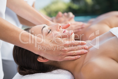 Peaceful couple enjoying couples massage poolside