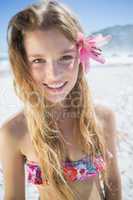 Beautiful smiling blonde with flower hair accessory on the beach