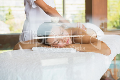 Brunette enjoying a peaceful massage with eyes closed