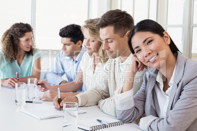 Casual businesswoman smiling at camera during meeting