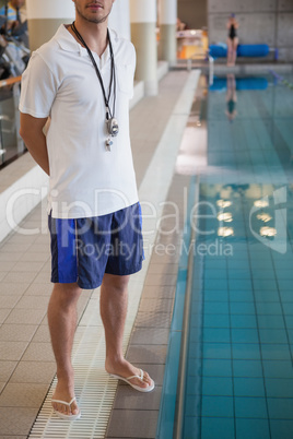Swimming coach standing by the pool