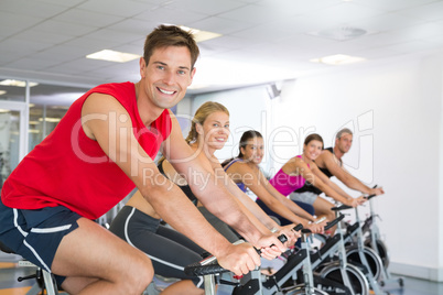 Man smiling at camera during spin class