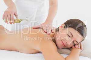 Attractive woman getting massage oil on her back