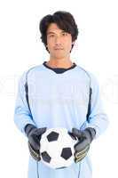 Goalkeeper in blue holding ball