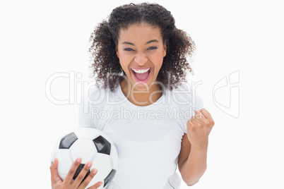 Pretty girl holding football and cheering at camera