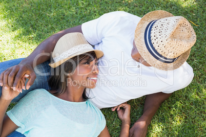 Happy couple lying in garden together cuddling