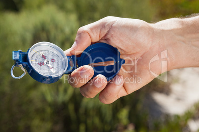 Hiker holding his compass in the countryside