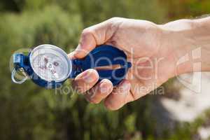 Hiker holding his compass in the countryside