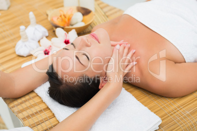 Smiling brunette enjoying a head massage Smiling brunette enjoying a head massage