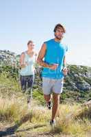 Fit couple jogging through countryside