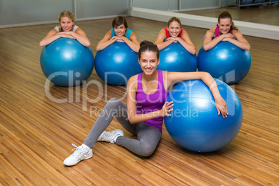 Fitness class posing with exercise balls in studio