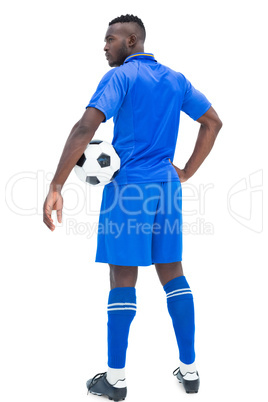 Football player in blue holding ball