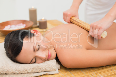 Beautiful brunette enjoying a bamboo roller massage