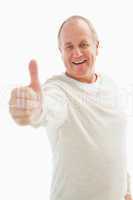 Happy mature man showing thumbs up to camera