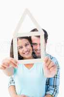 Happy young couple with house shape