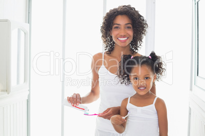 Pretty mother with her daughter brushing their teeth Pretty mother with her daughter brushing their teeth