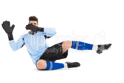 Goalkeeper in blue making a save