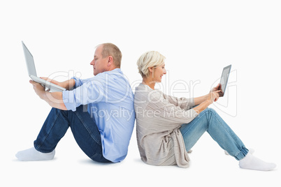 Mature couple using laptop and tablet pc