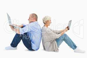 Mature couple using laptop and tablet pc