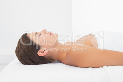 Beautiful woman lying on massage table at spa center