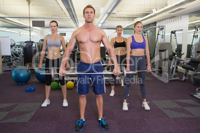 Fitness class lifting barbells together