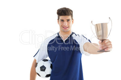 Football player in blue jersey holding winners cup