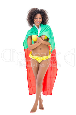 Girl wrapped up in portugal flag smiling at camera