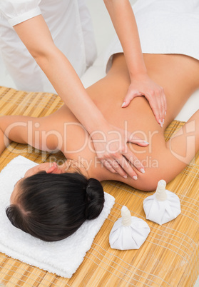 Woman enjoying a herbal compress massage