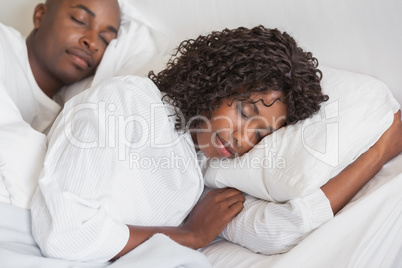 Happy couple sleeping together in bed