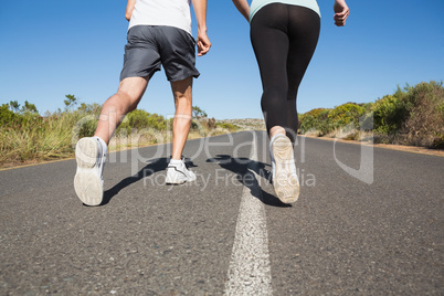 Fit couple running on the open road together