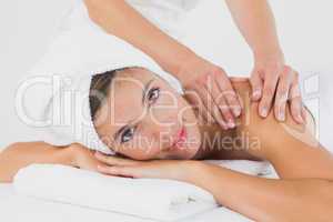 Attractive woman receiving shoulder massage at spa center