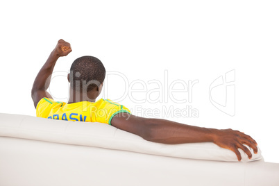 Man sitting on sofa and cheering