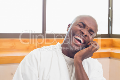 Laughing man in bathrobe talking on phone