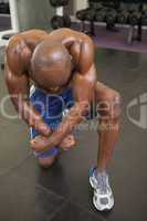 Shirtless muscular man flexing muscles in gym