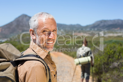 Hiking couple walking on mountain trail man smiling at camera