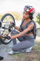 Fit woman fixing the chain on her bike